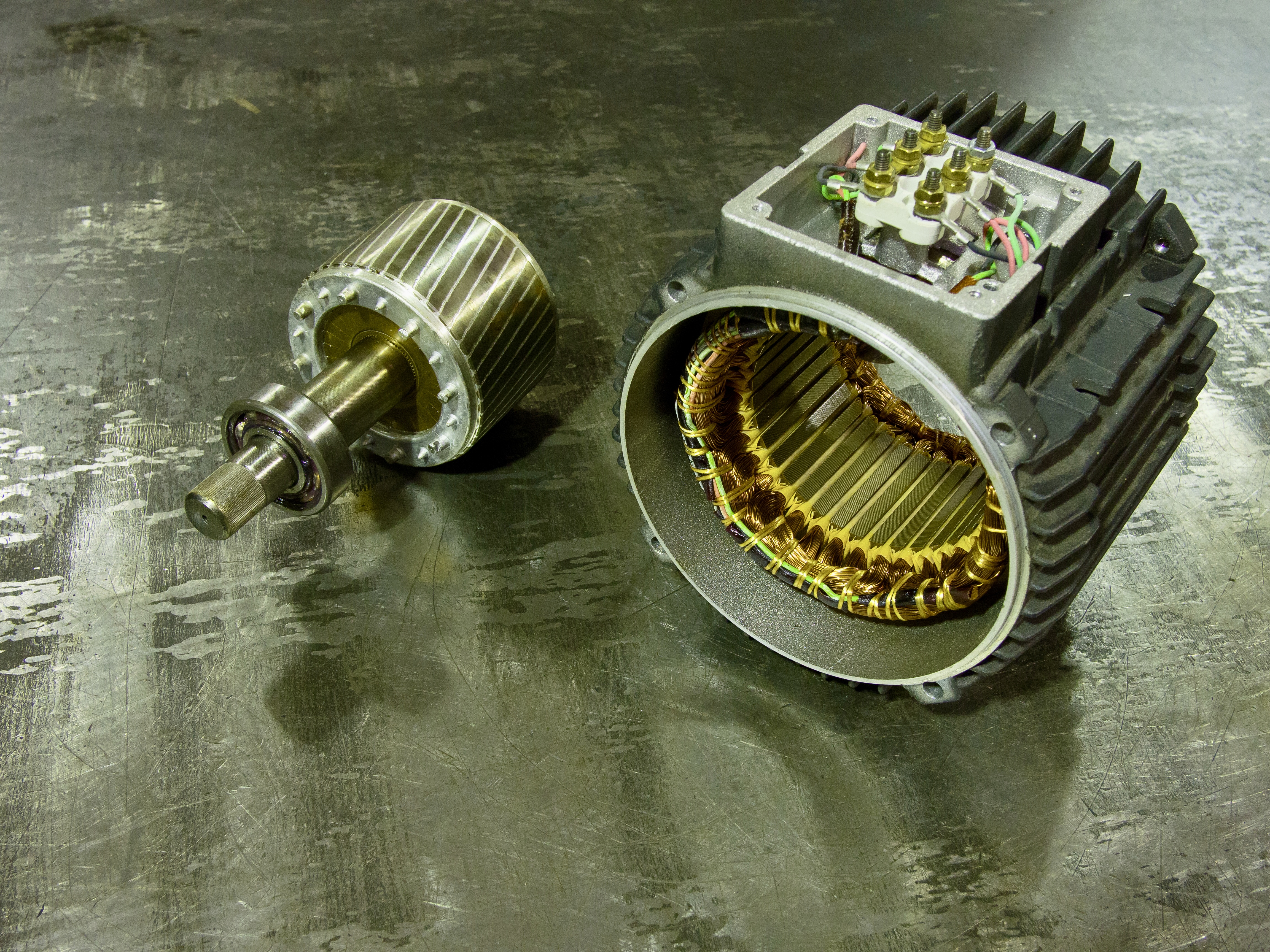 disassembled industrial induction electric motor: rotor on the left statoron the right